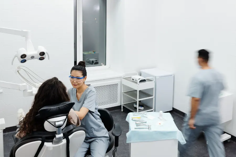 Dentista conversando com paciente em consultório de clínica odontológica